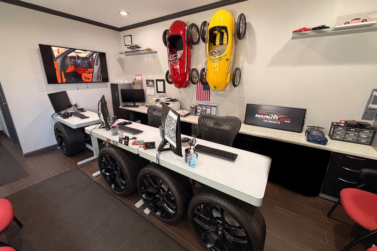 Sales office at Maruti Auto Sales, with desks built on car wheels and two vintage pedal cars on the wall