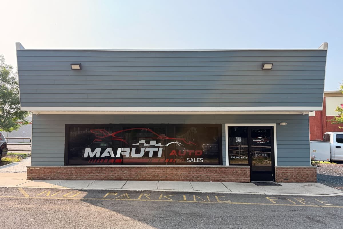 Storefront of Maruti Auto Sales, a used car dealer in East Brunswick, NJ, with the phone number and hours on the door